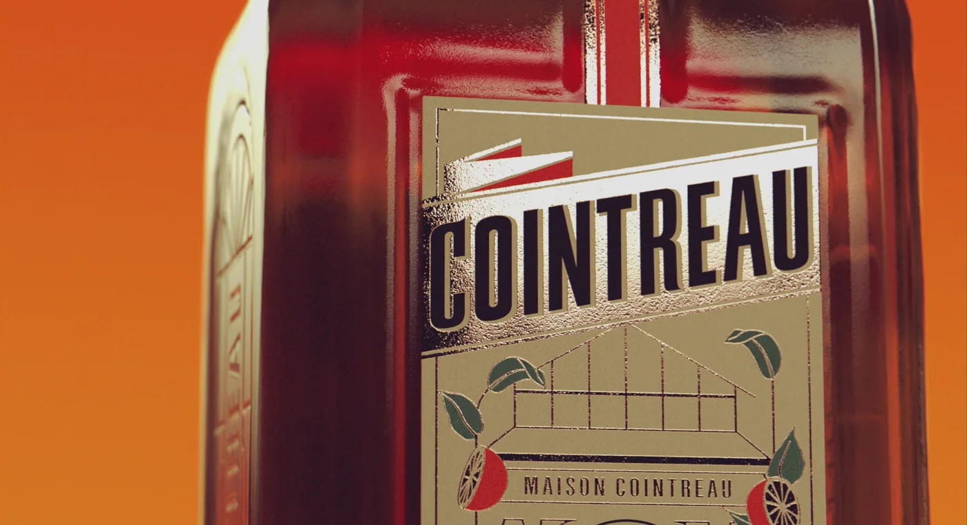 Gros plan sur l'étiquette Maison Cointreau reconstituée en 3D : dorures, serre gravée et agrumes stylisés, avec le grain du papier restitué.