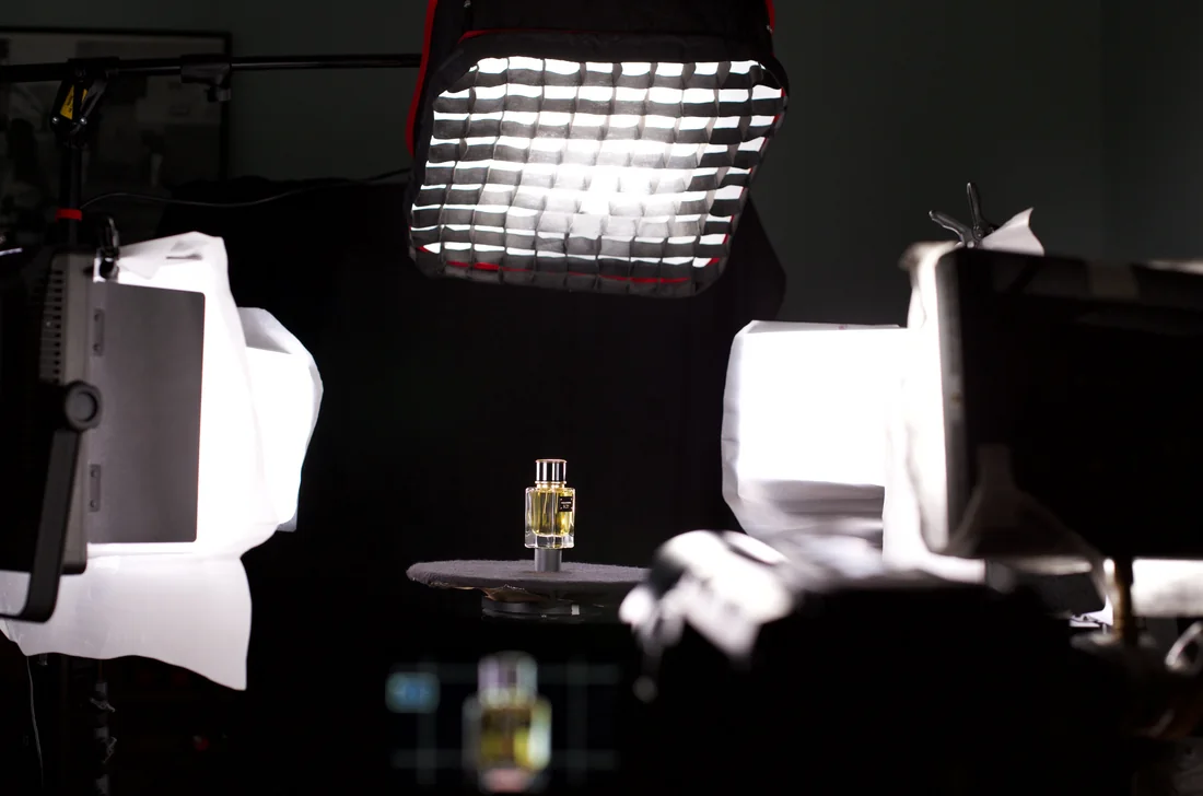 Tournage en studio d'un flacon de parfum, entouré de panneaux de lumière, pour la production du contenu Fifi Awards.
