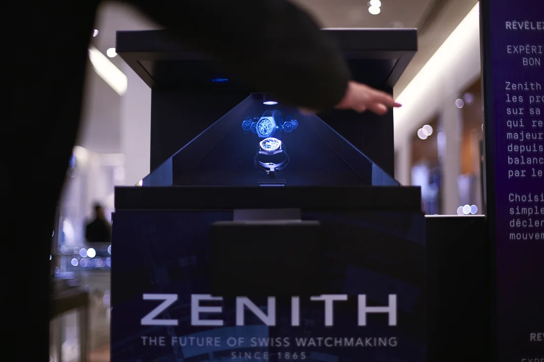 Appareil holographique Zenith sur un stand de salon, une visiteuse interagissant devant le dispositif.