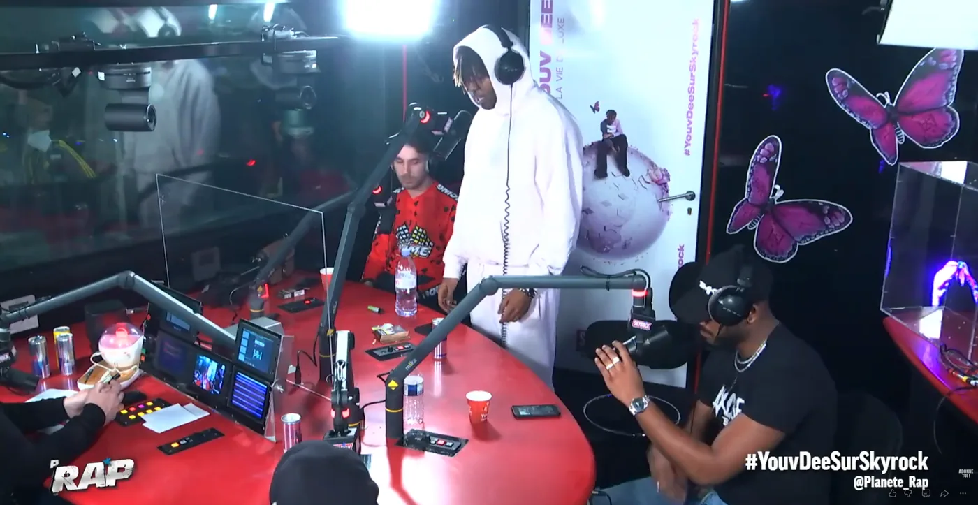 Le studio Planète Rap de Skyrock habillé aux couleurs de l'album La Vie de Luxe : décor imprimé au visuel de pochette et papillons découpés sur les vitres.